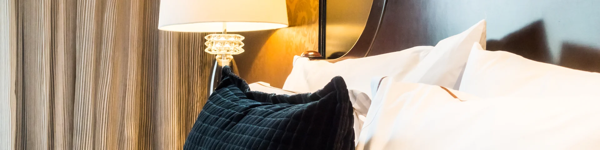 White pillow on bed with table light lamp decoration in bedroom interior